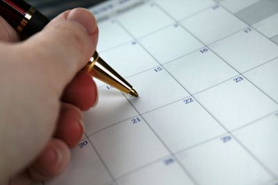 Person writing on calendar