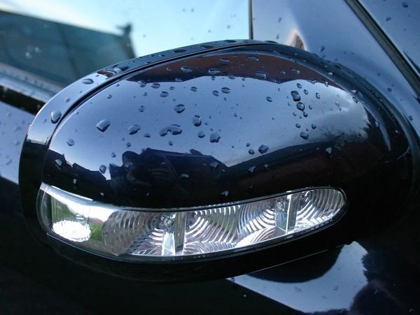 vehicle side mirror with water beading on it from touch free car wash in Olathe KS