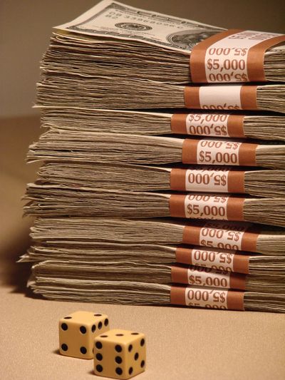 Stacks of $5,000 bills with two dice in front.
