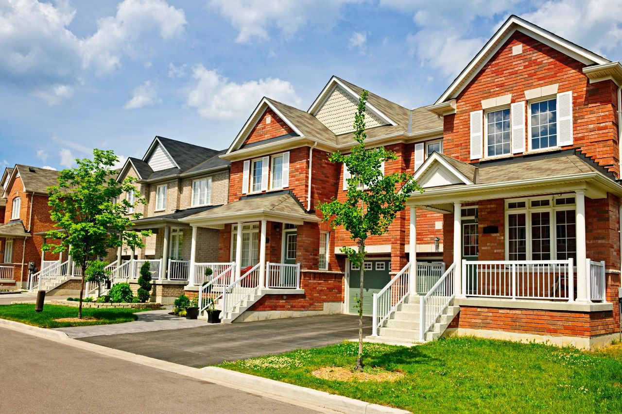 Red and yellow brick homes on a suburban street.