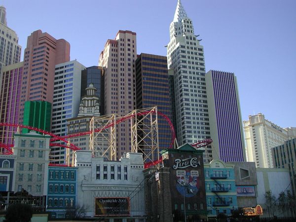 Cityscape with colorful buildings and a red roller coaster track.