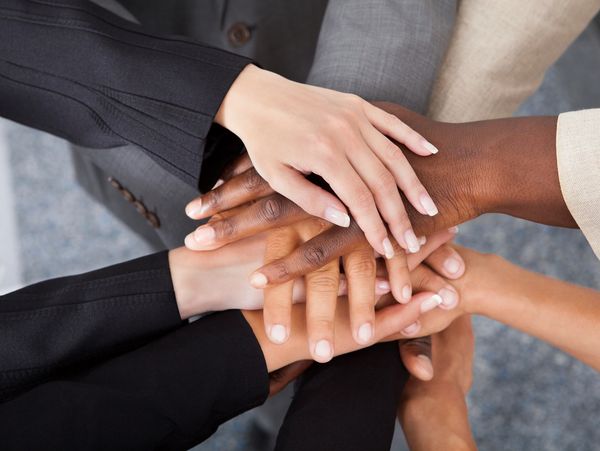 Diverse hands stacked together symbolizing unity and teamwork.