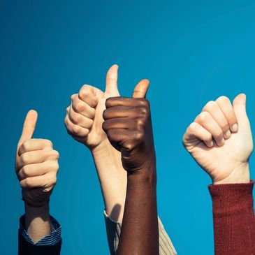 Mixed group of thumbs up in the sky