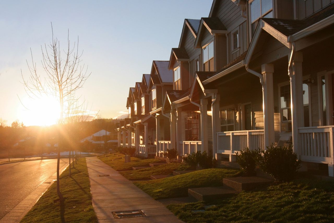 The sun sets on a row of single family homes.