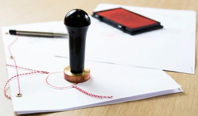 a notary stamp, papers, an ink pen and a cell phone