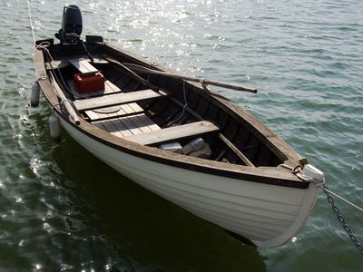A small wooden motorboat on water.