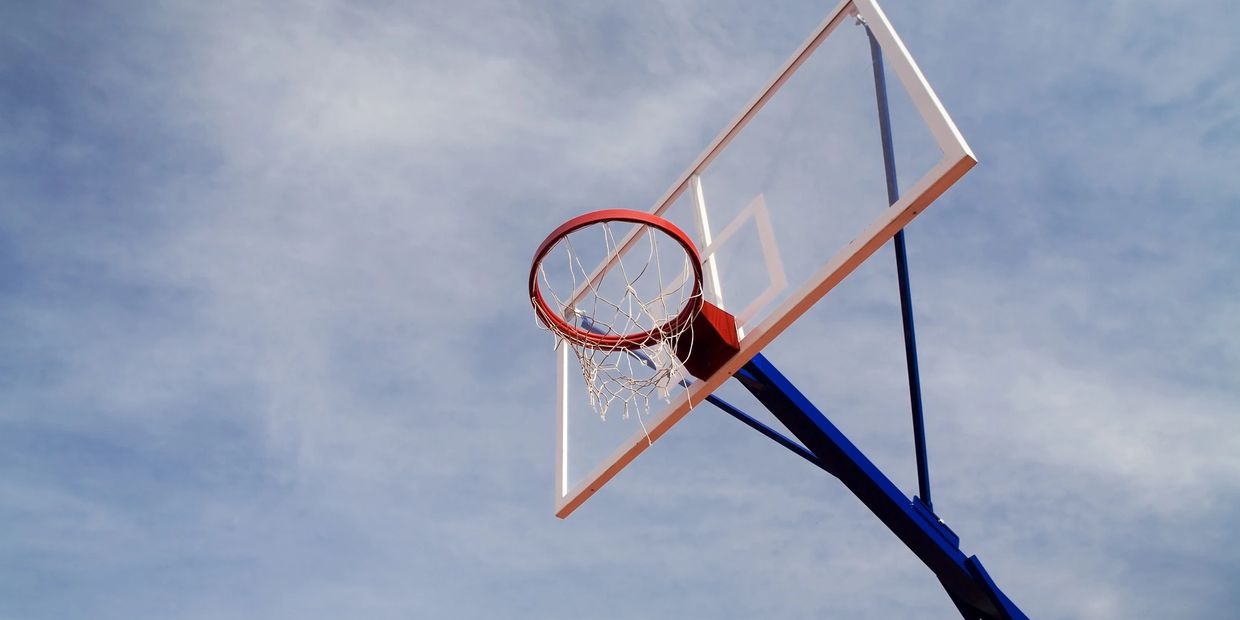 Basketball hoop with net against a clear sky.