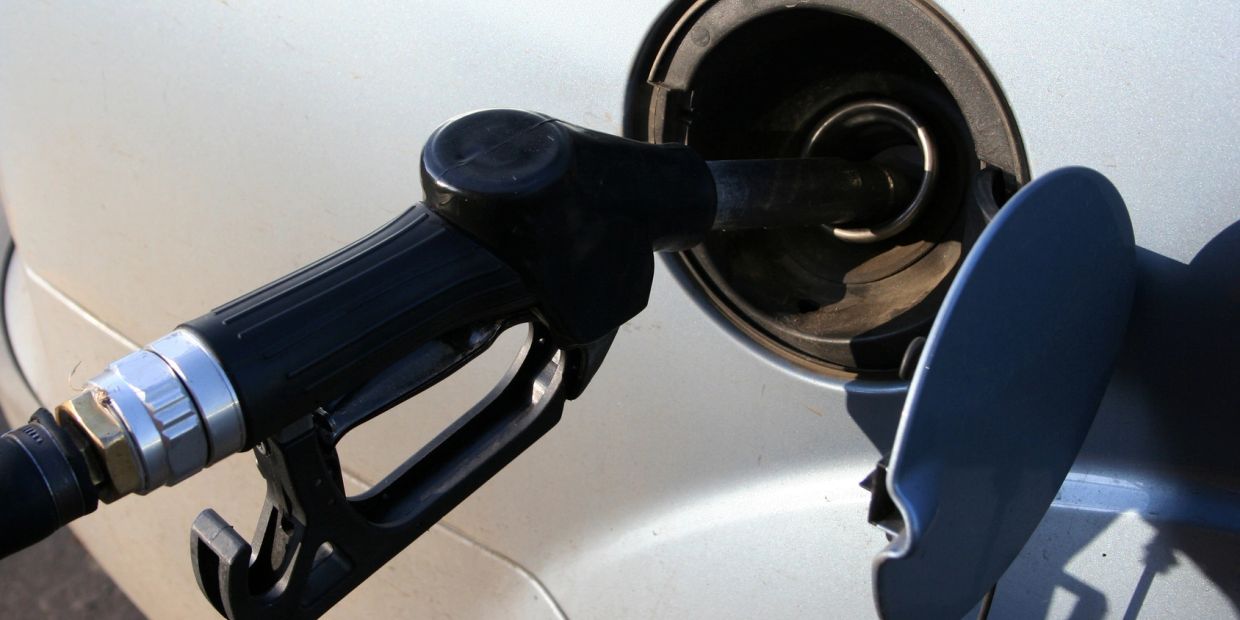 A fuel nozzle inserted into a car's gas tank during refueling.
