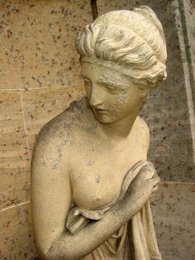 Classic statue of a woman with draped clothing.