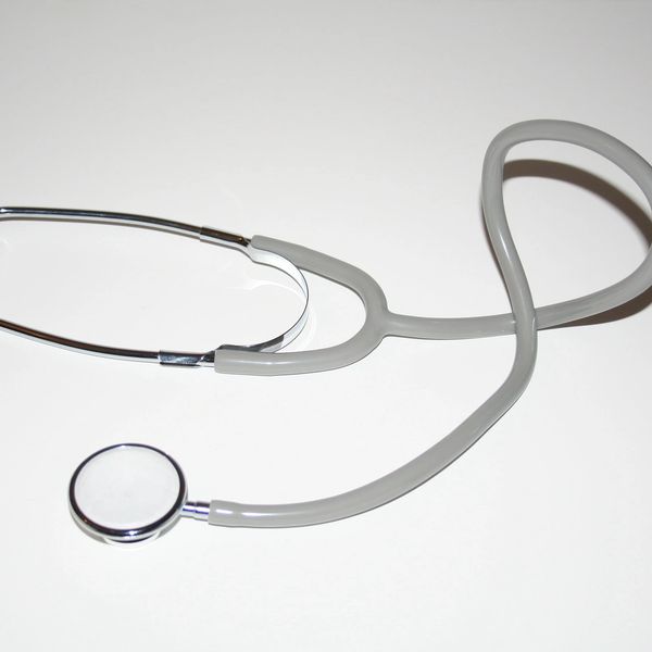 A gray stethoscope on a white surface.