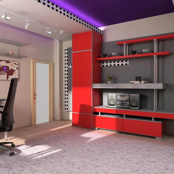 Modern office with red and gray decor, featuring a desk, chair, and shelves with decorative items.