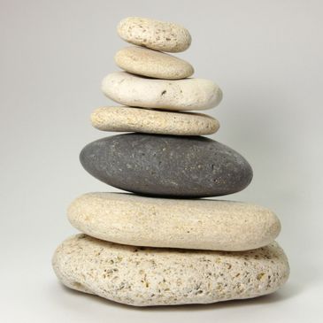 Stack of smooth, rounded stones balanced in a pyramid shape.