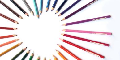 Colored pencils arranged in a heart shape on a white background.