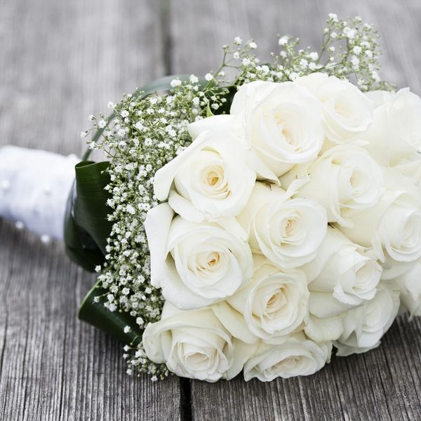 Elegant bouquet of white roses on wooden surface.