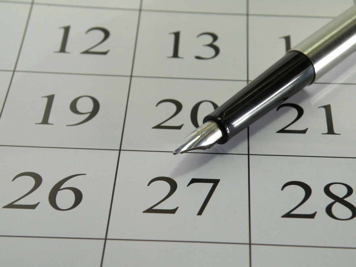 A pen pointing at the 27th on a calendar.