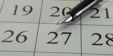 Pen pointing at the date 27 on a calendar.