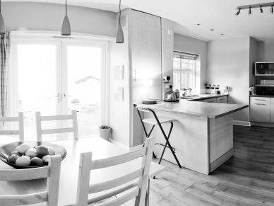 Bright modern kitchen with dining area and wooden floor.