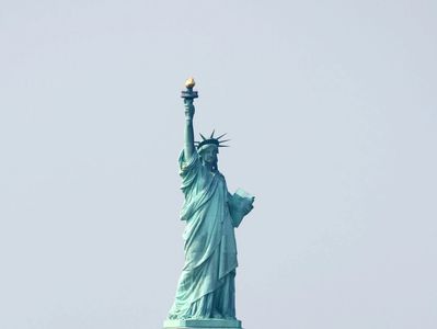 The Statue of Liberty stands tall against a clear sky.