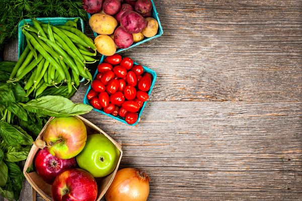 Fresh fruits and vegetables arranged on a rustic wooden surface.