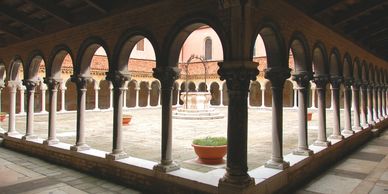 Sunlit courtyard with arches and columns.