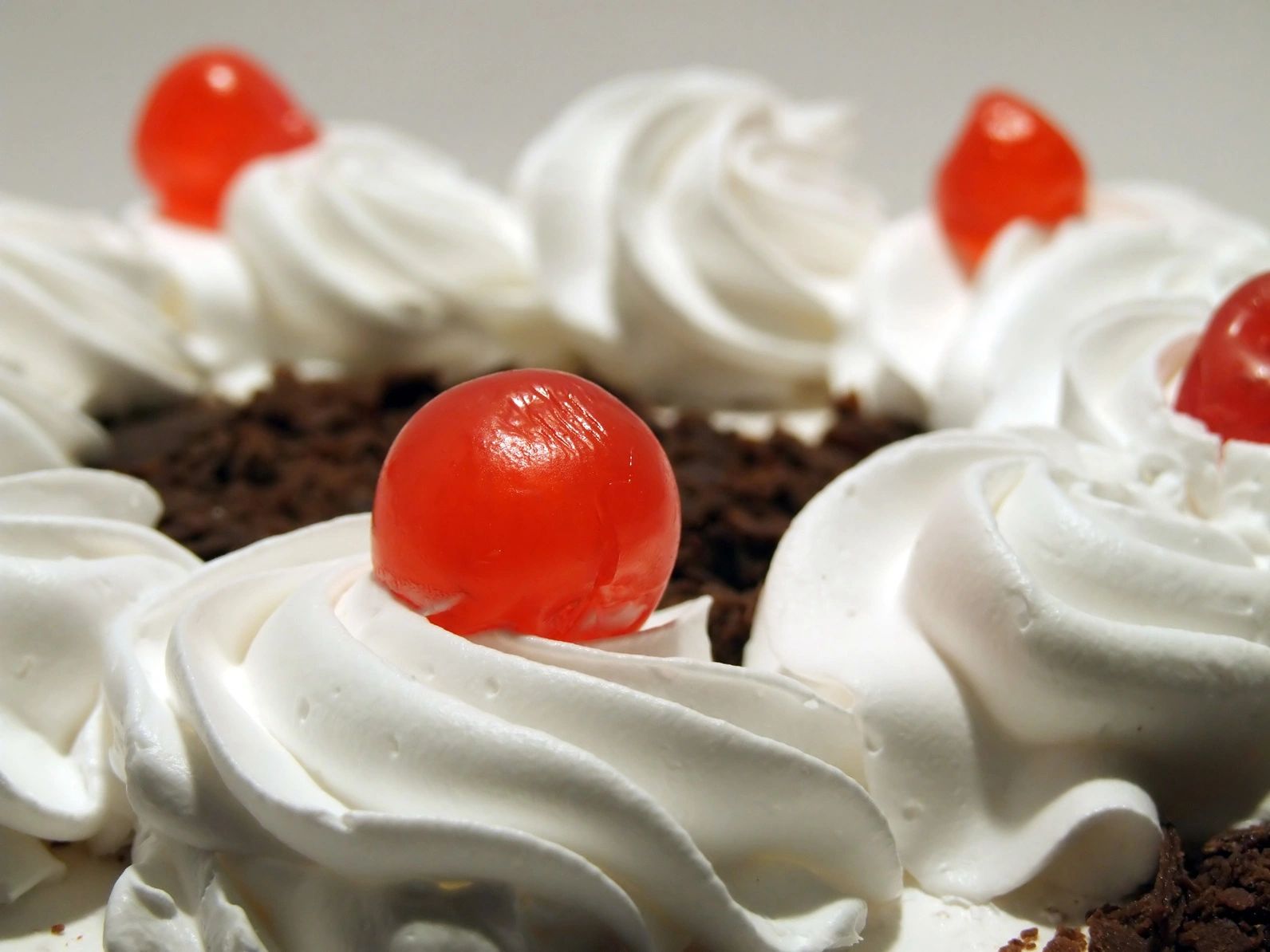 Whipped cream cake topped with cherries.