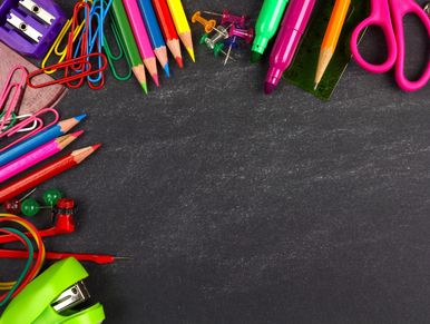 Colorful school supplies arranged on blackboard background.