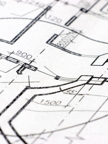 Close-up of architectural blueprint with precise measurements and curved lines.