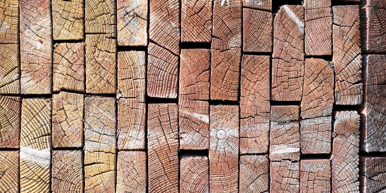 Stacked wooden logs showing detailed grain patterns and cracks.