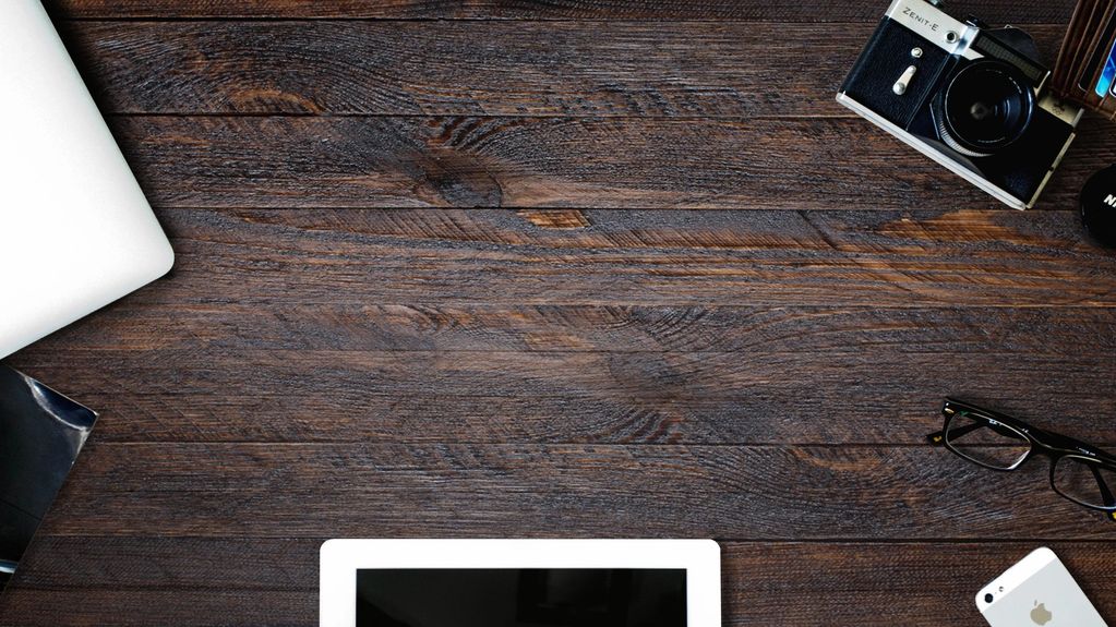 Workspace with tech gadgets on wooden desk.