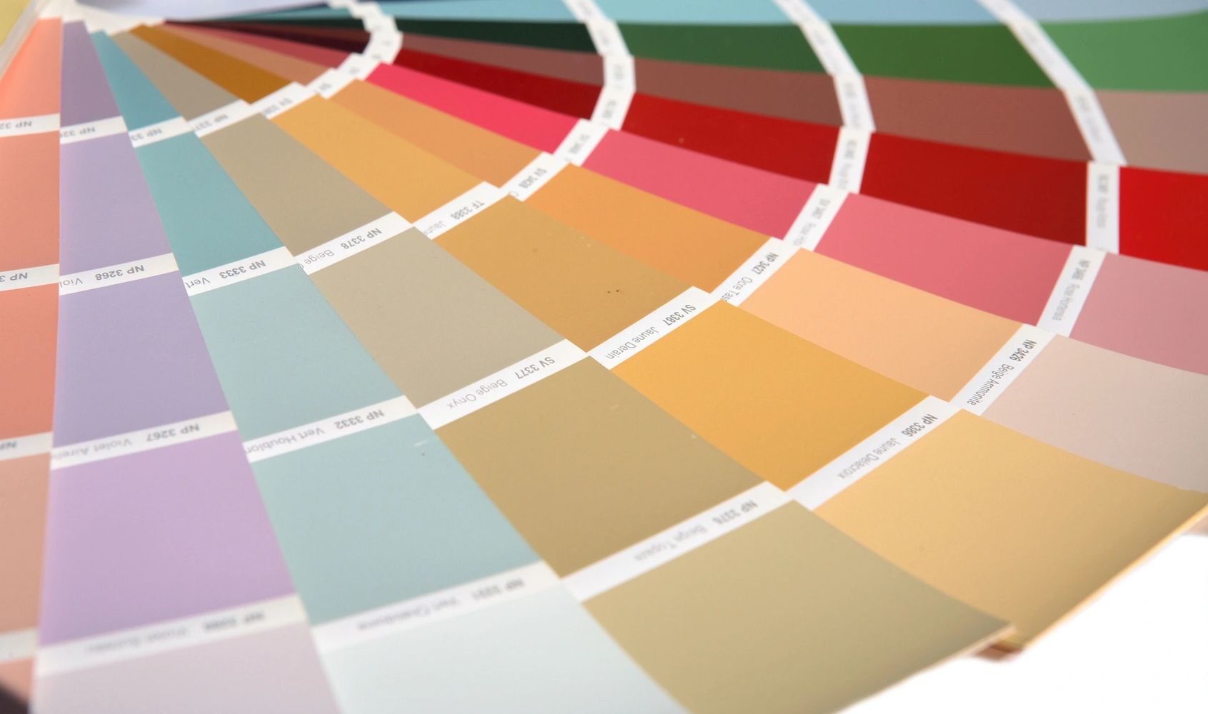 Close-up of a fan of colorful paint swatches arranged in a gradient.