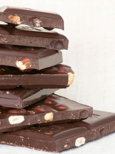 Stack of dark chocolate bars with nuts embedded.