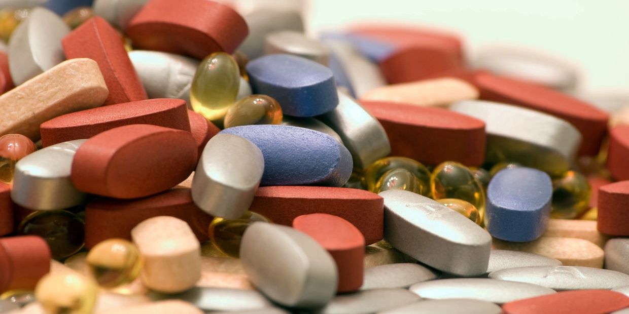 Close-up of assorted colorful pills and capsules piled together.