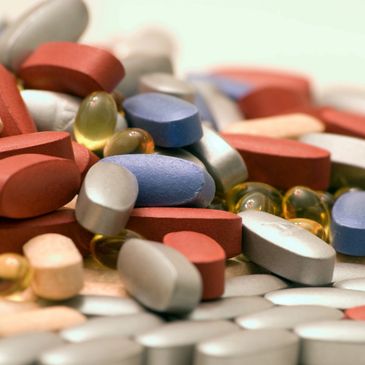 Assorted colorful pills and capsules scattered together.