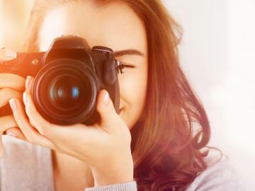 Woman taking a photo with a camera.