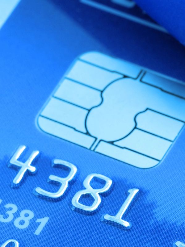 Close-up of a blue credit card chip and embossed digits.