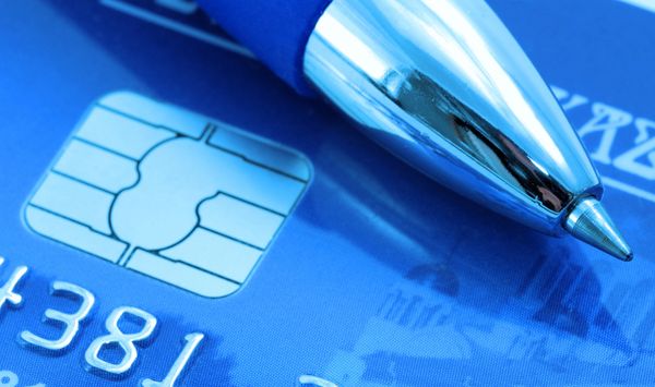 Ballpoint pen on blue credit card close-up.
