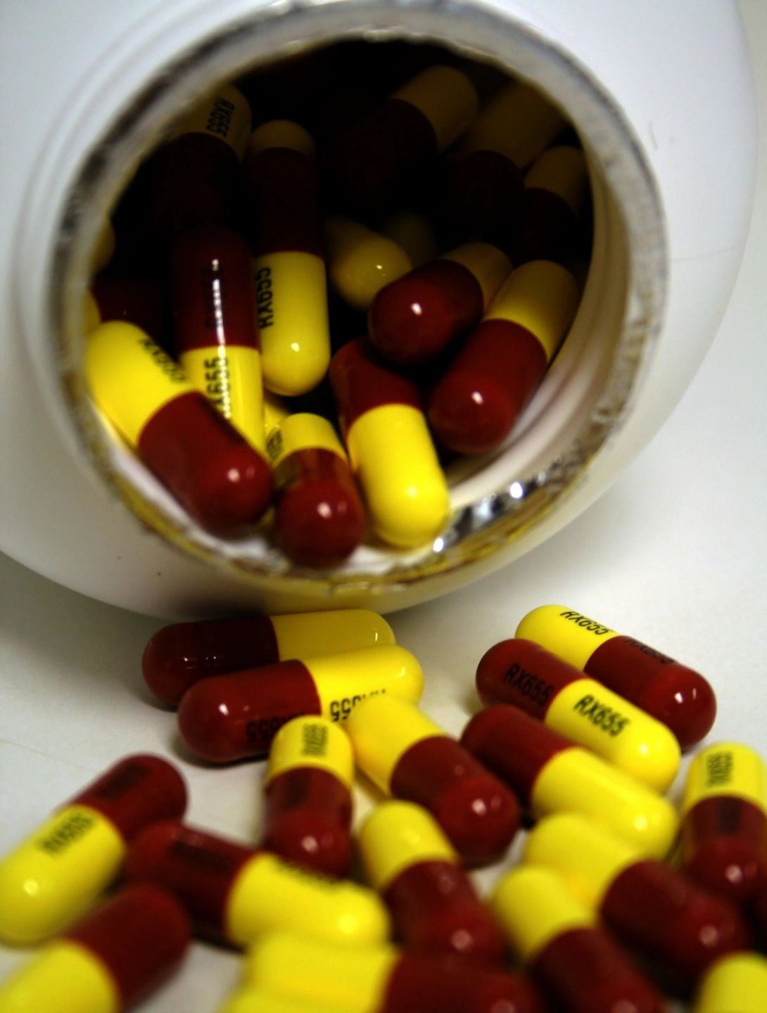 A pill bottle with several red and yellow pills falling out. Click the link for more information regarding hormone replacement therapy for men and women between the ages of 30 and 65 suffering from low testosterone in Pueblo Colorado.
