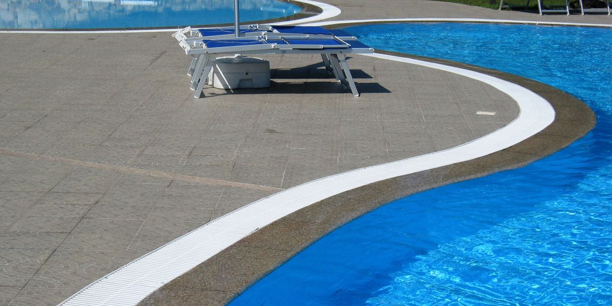 Experienced pool builders installing custom tile in a residential pool.