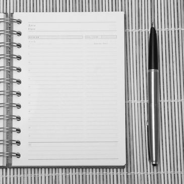 A notebook and pen on a bamboo table