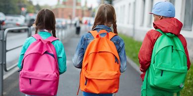 three young students walking with backpacks