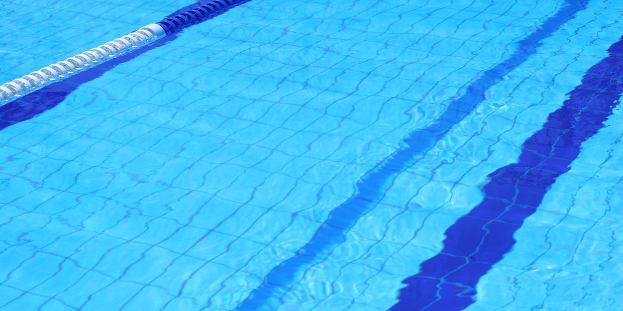 Close-up of a calm swimming pool lane with blue water.