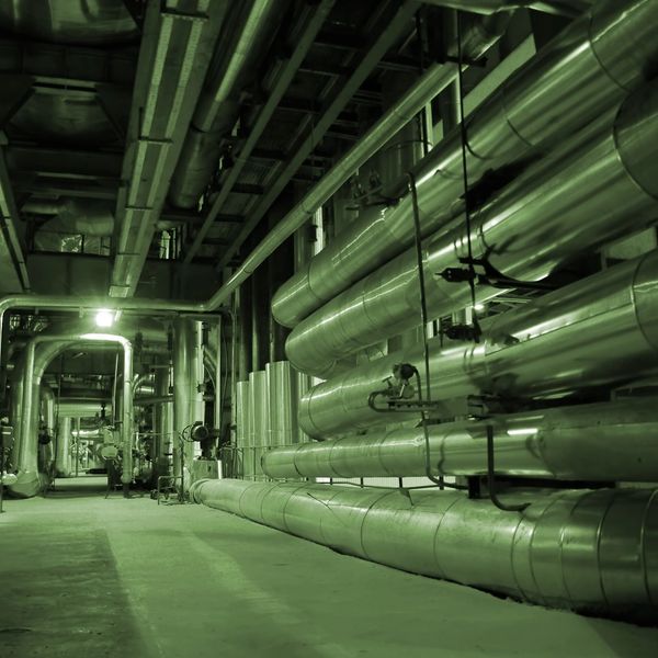 Industrial corridor with large metal pipes and ducts.