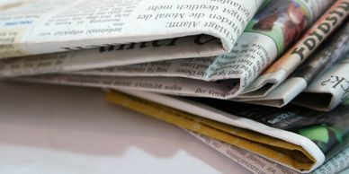 A stack of folded newspapers on a flat surface.