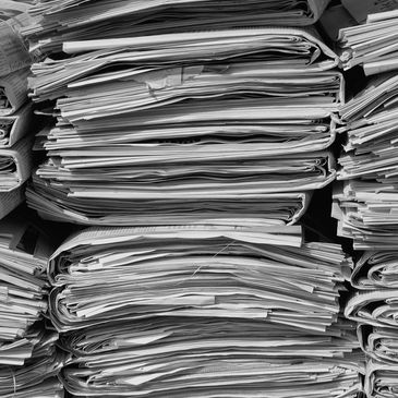 Stacks of folded newspapers piled up.