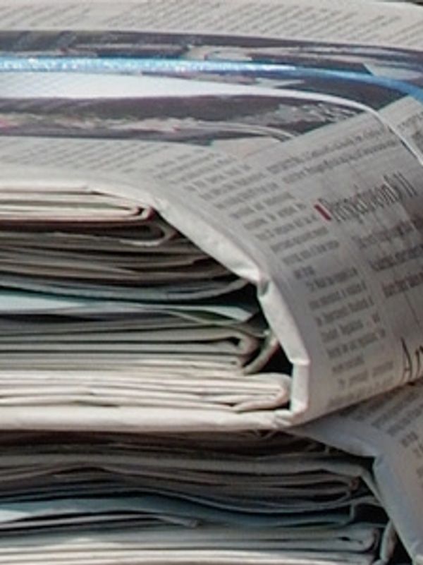 Stack of folded newspapers piled closely together.