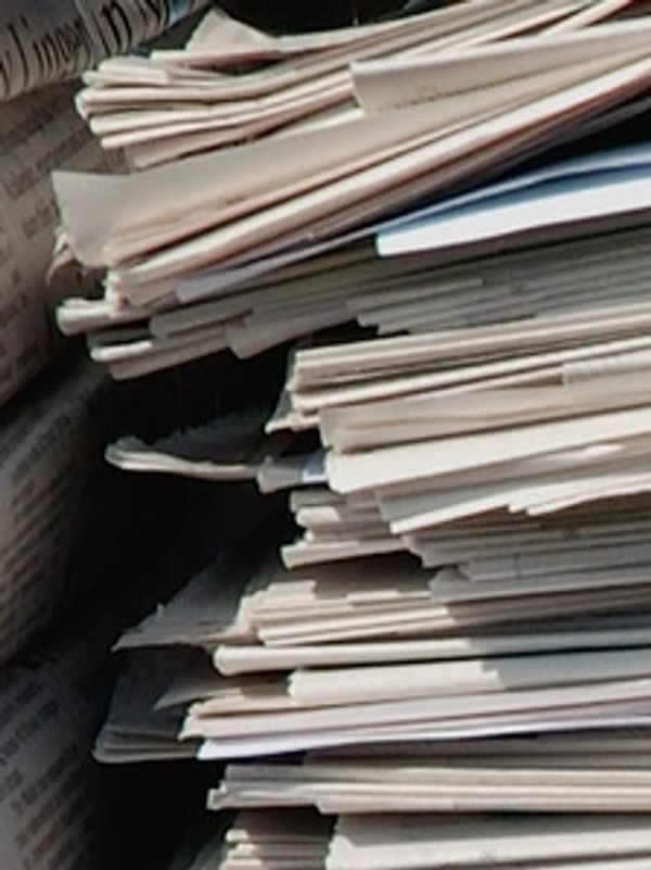 Stack of folded newspapers piled closely together.