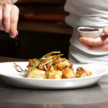 Private chef plating a gourmet meal for LuxxeDates clients