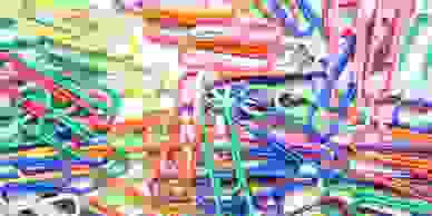 Paperclips of various colours spread out on a table.