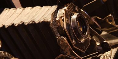 Close-up of a vintage bellows camera lens and body.