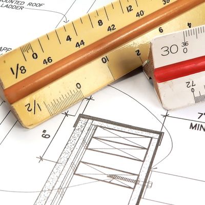 Architectural blueprint with measuring tools and a pencil.
